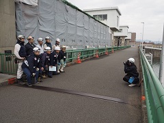 現場で機構職員と作業員の皆さんを撮影